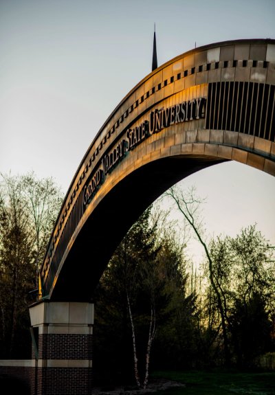 GVSU arch at entrance of campus at sunset